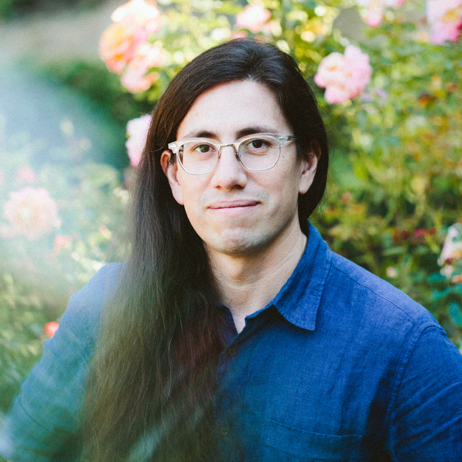 [A photograph of David smiling in a rose garden.]